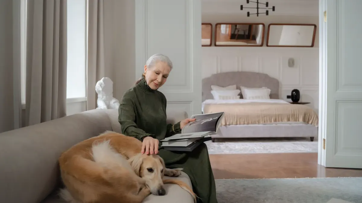 Pet owner reading the ingredient label on a dog supplement bag at home with a senior dog nearby
